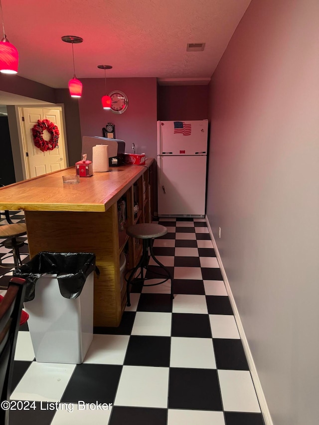 kitchen featuring white fridge and decorative light fixtures