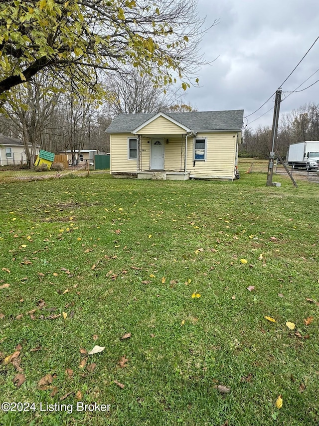 ranch-style house with covered porch and a front lawn