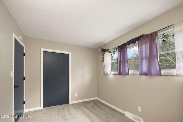 unfurnished bedroom with carpet and a textured ceiling