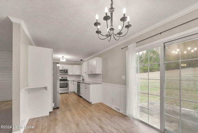 kitchen featuring white cabinetry, sink, stainless steel appliances, an inviting chandelier, and light wood-type flooring