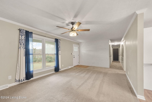 carpeted empty room featuring a textured ceiling, ceiling fan, and ornamental molding