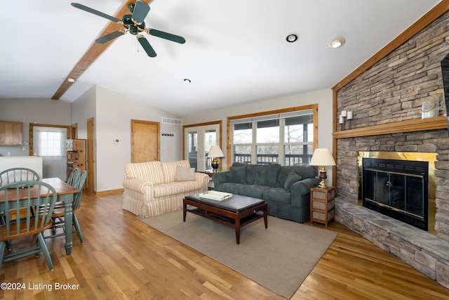 living room with vaulted ceiling with beams, plenty of natural light, and light hardwood / wood-style floors