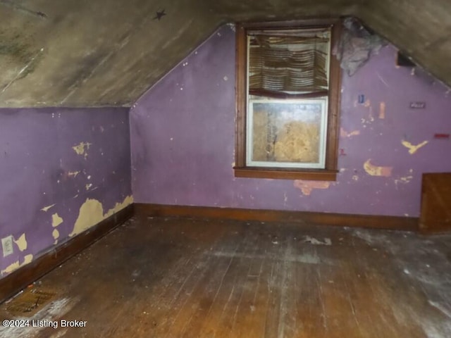 additional living space with wood-type flooring and lofted ceiling