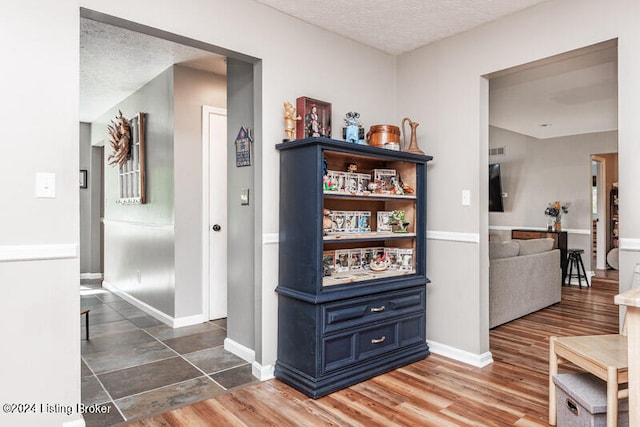 hallway with a textured ceiling and dark wood-type flooring