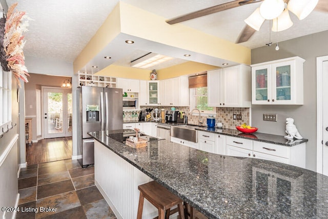 kitchen with dark stone counters, white cabinets, and stainless steel appliances