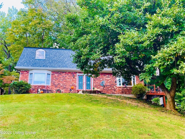 view of front of property with a deck and a front lawn