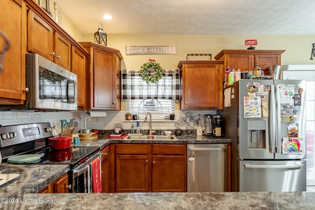 kitchen featuring backsplash, a healthy amount of sunlight, sink, and appliances with stainless steel finishes