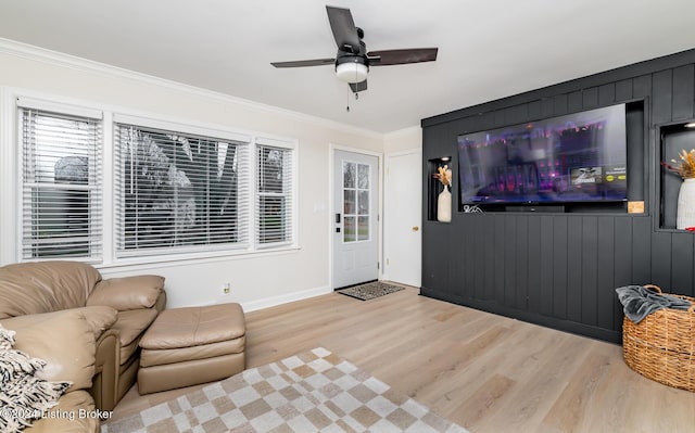 living room featuring light hardwood / wood-style floors, ceiling fan, and crown molding