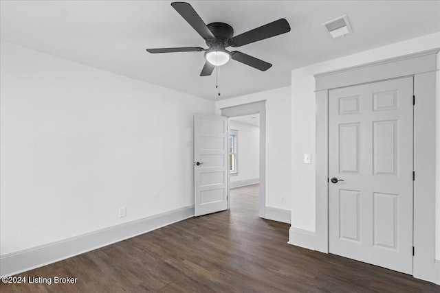 empty room with dark hardwood / wood-style flooring and ceiling fan