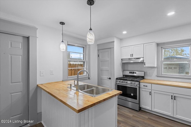 kitchen with wood counters, white cabinets, sink, stainless steel gas stove, and kitchen peninsula