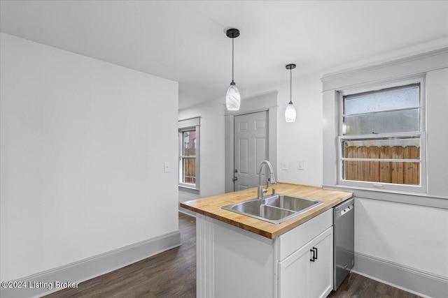 kitchen with kitchen peninsula, dark hardwood / wood-style flooring, sink, white cabinets, and butcher block countertops