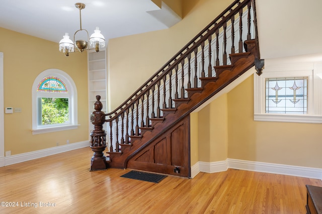 staircase featuring a chandelier and wood-type flooring