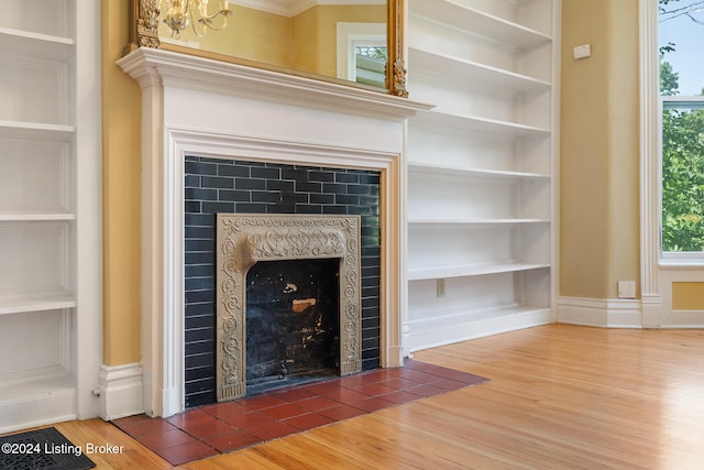 room details with hardwood / wood-style floors, built in features, and ornamental molding