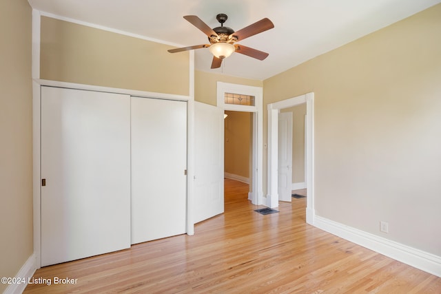 unfurnished bedroom featuring ceiling fan, light hardwood / wood-style floors, and a closet