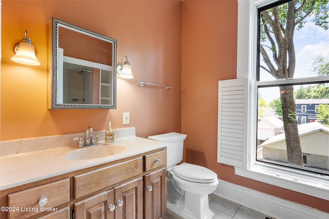 bathroom with toilet, vanity, and tile patterned floors