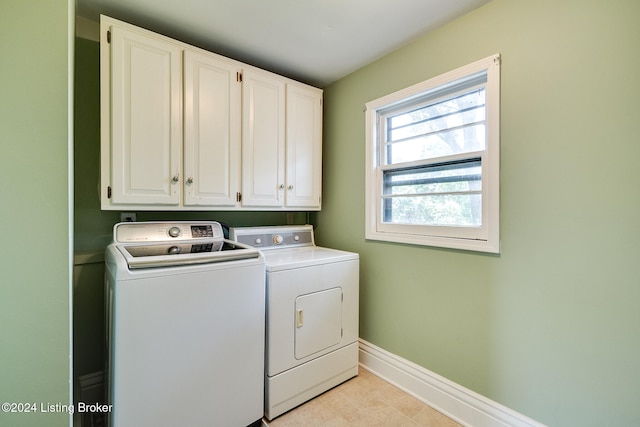 laundry room featuring cabinets and washer and clothes dryer