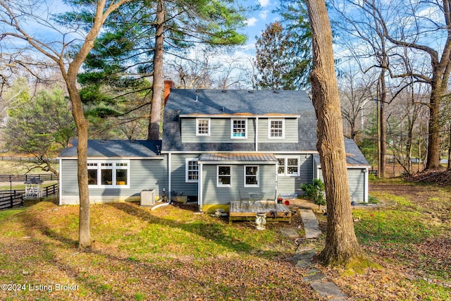 rear view of property featuring a yard, central AC unit, and a deck