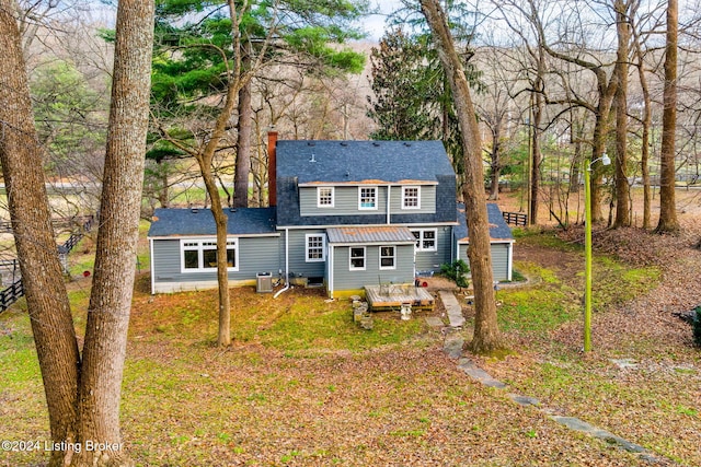 rear view of property featuring central air condition unit and a wooden deck