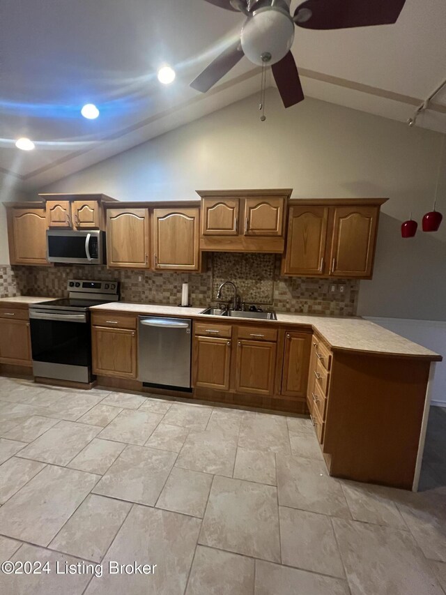 kitchen with tasteful backsplash, sink, stainless steel appliances, and vaulted ceiling