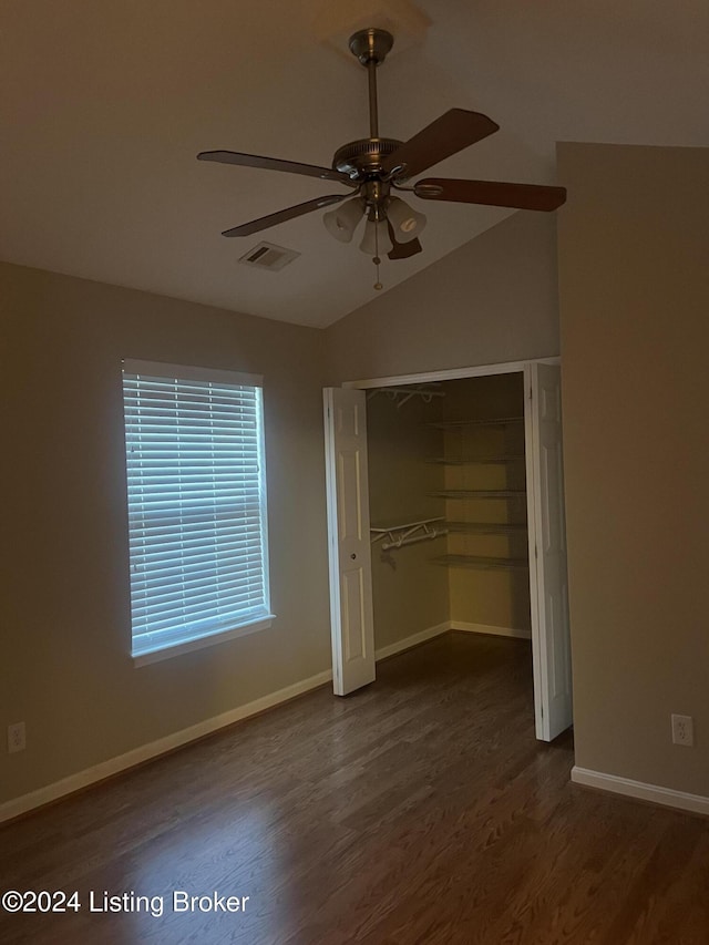 unfurnished bedroom with a closet, ceiling fan, dark hardwood / wood-style flooring, and vaulted ceiling