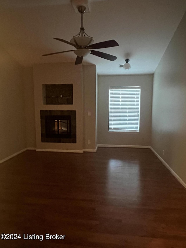 unfurnished living room featuring ceiling fan and dark wood-type flooring