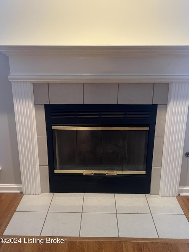 room details with a tiled fireplace and wood-type flooring