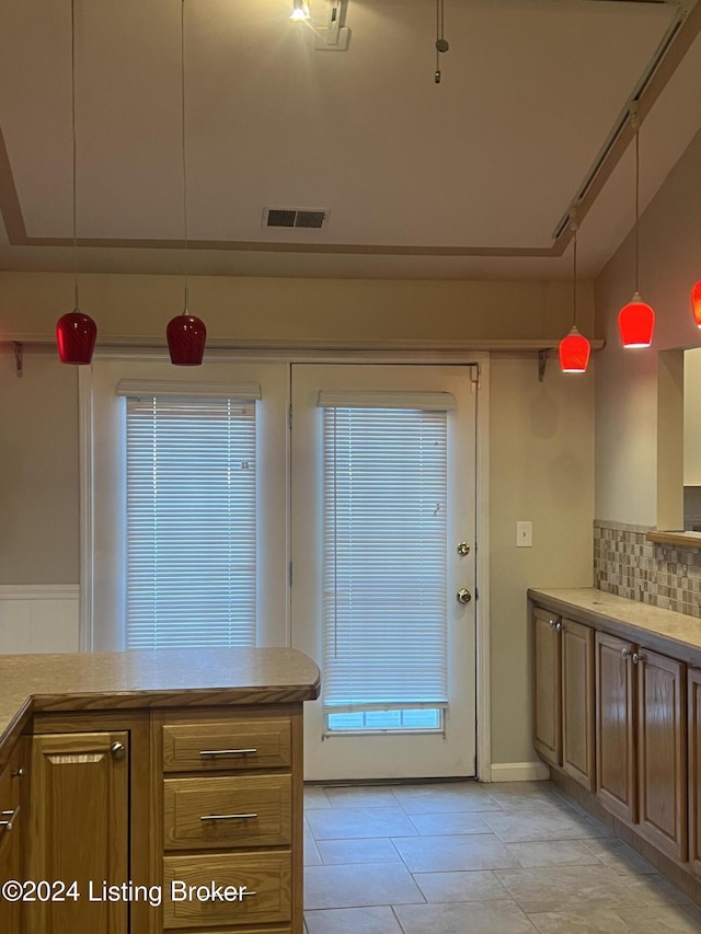 kitchen with backsplash, decorative light fixtures, and a wealth of natural light