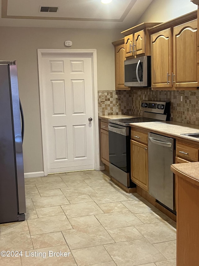 kitchen with backsplash and appliances with stainless steel finishes