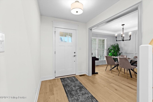 entryway featuring wood-type flooring and a notable chandelier