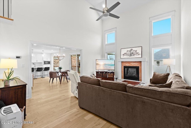 living room featuring a high ceiling, light hardwood / wood-style floors, and plenty of natural light