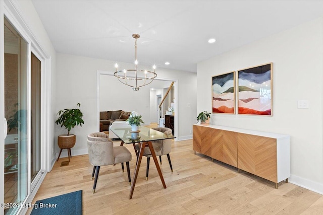 dining room with light wood-type flooring and a chandelier