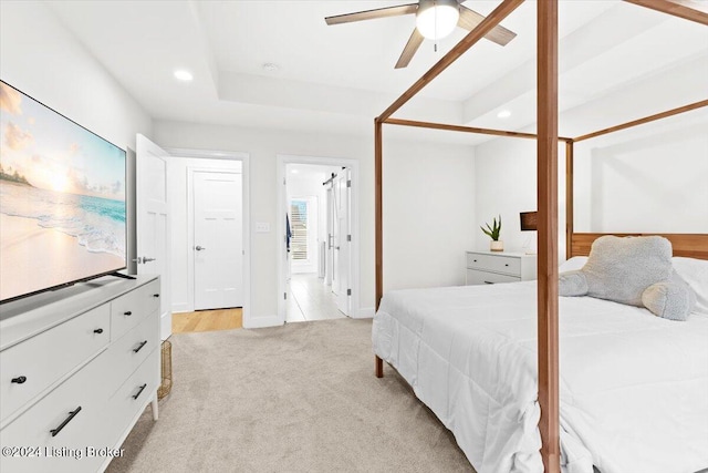 bedroom featuring ensuite bathroom, ceiling fan, and light colored carpet