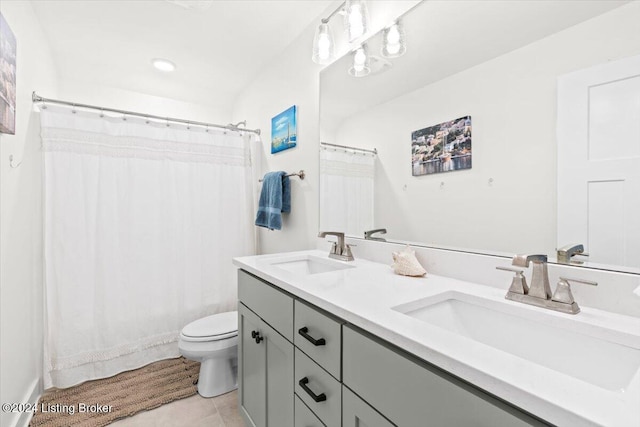 bathroom with toilet, vanity, and tile patterned floors