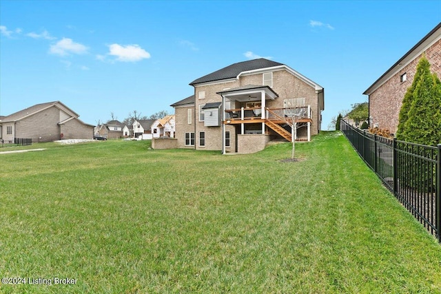 back of house with a deck and a yard