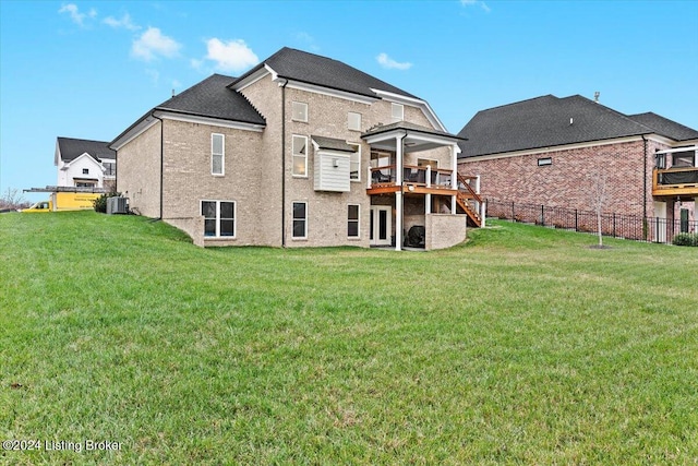 rear view of property with a yard, cooling unit, and a deck