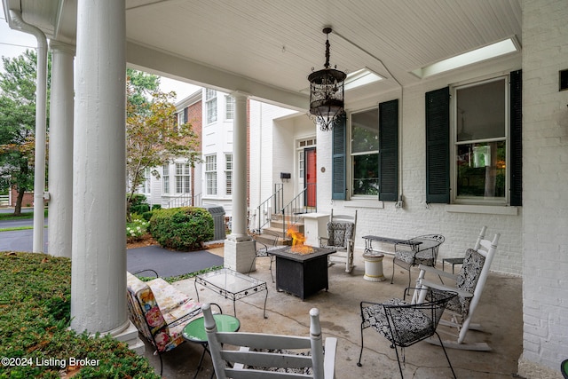 view of patio / terrace with a fire pit and a porch