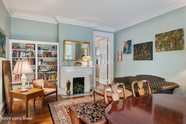 living area with crown molding and hardwood / wood-style floors