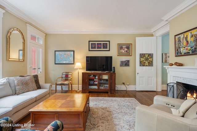 living room featuring hardwood / wood-style floors, crown molding, and a fireplace