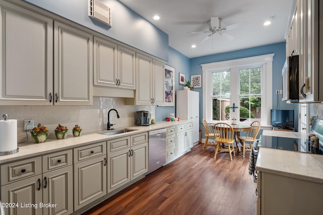 kitchen featuring light stone countertops, ceiling fan, sink, stainless steel dishwasher, and dark hardwood / wood-style floors