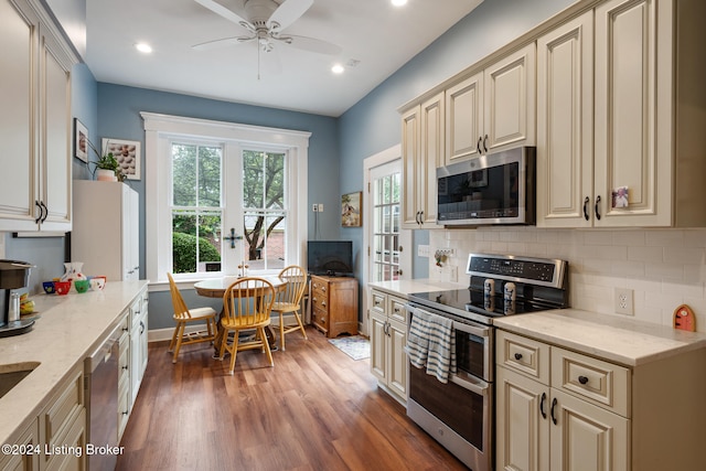 kitchen with dark hardwood / wood-style flooring, ceiling fan, cream cabinets, and stainless steel appliances