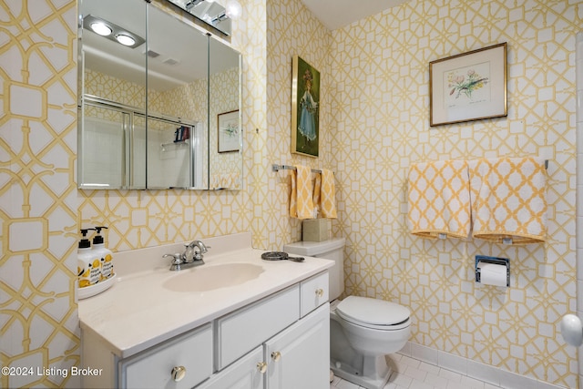 bathroom with tile patterned floors, vanity, toilet, and a shower with shower door