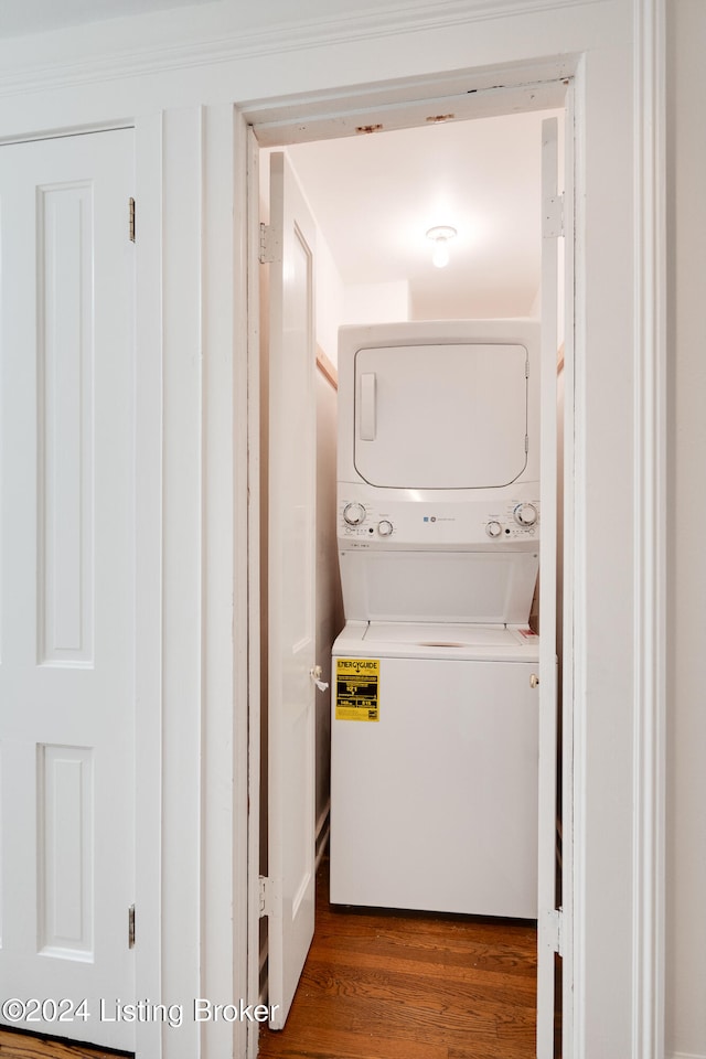 washroom with dark hardwood / wood-style floors and stacked washer / drying machine