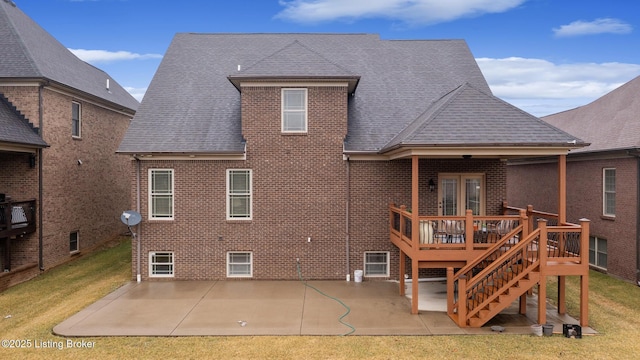 back of house featuring brick siding, a shingled roof, stairs, and a patio