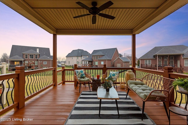 deck at dusk with a ceiling fan and a residential view