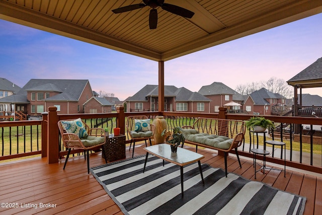 deck featuring an outdoor living space, a residential view, and a ceiling fan