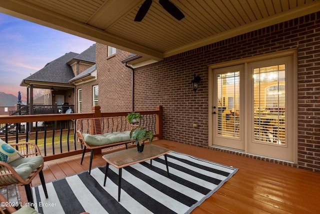 deck at dusk featuring ceiling fan