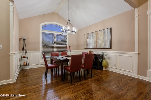 dining space with dark wood finished floors, decorative columns, lofted ceiling, wainscoting, and a chandelier