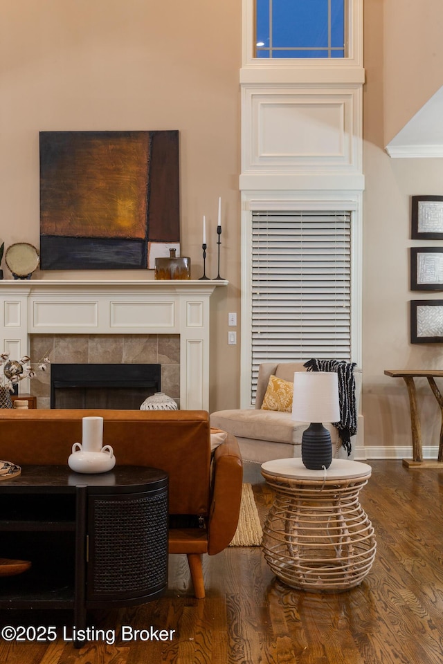 living area with a fireplace, wood finished floors, and baseboards