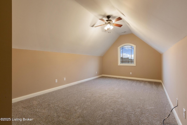 additional living space featuring lofted ceiling, carpet, a ceiling fan, and baseboards