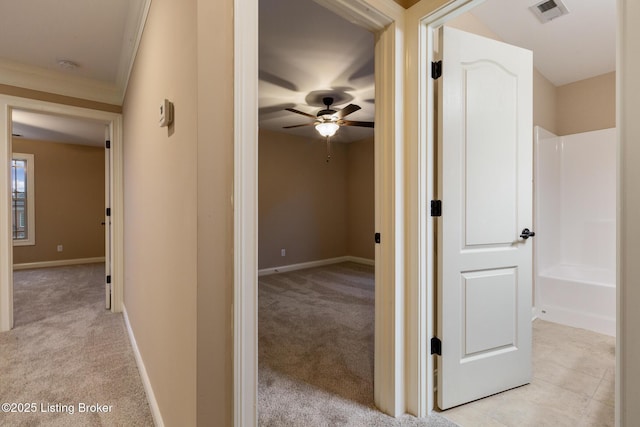 corridor featuring light carpet, baseboards, and visible vents